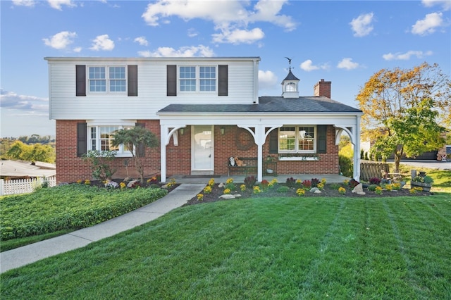 front facade with a front yard and covered porch