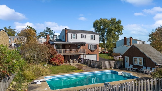 view of swimming pool with a patio and a diving board