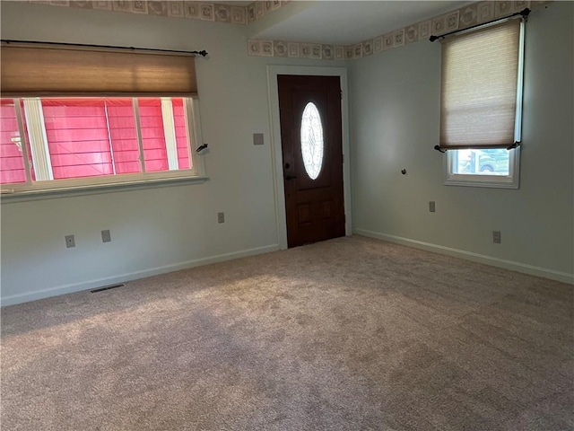 foyer featuring visible vents, baseboards, and carpet