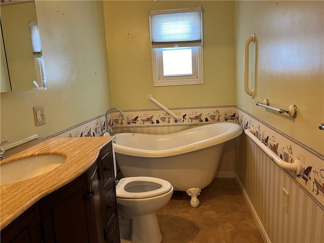 full bath with toilet, a freestanding bath, and vanity