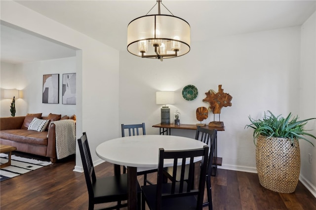 dining area featuring dark hardwood / wood-style flooring and a notable chandelier