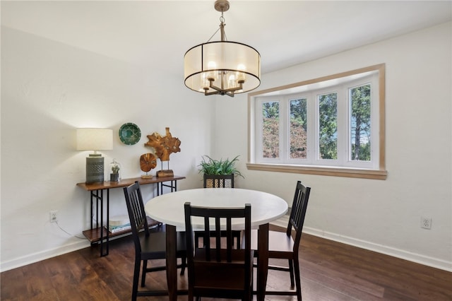 dining space with dark wood-type flooring and a notable chandelier