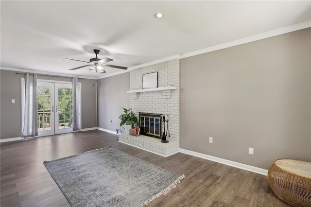 unfurnished living room with ceiling fan, dark hardwood / wood-style floors, crown molding, and a brick fireplace