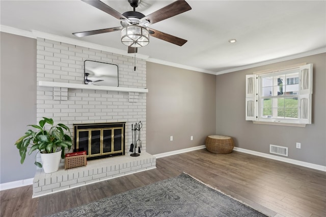 unfurnished living room featuring a fireplace, ornamental molding, hardwood / wood-style floors, and ceiling fan