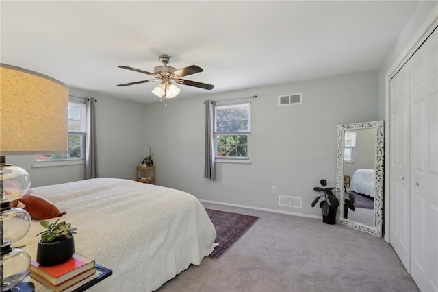 carpeted bedroom featuring ceiling fan and a closet