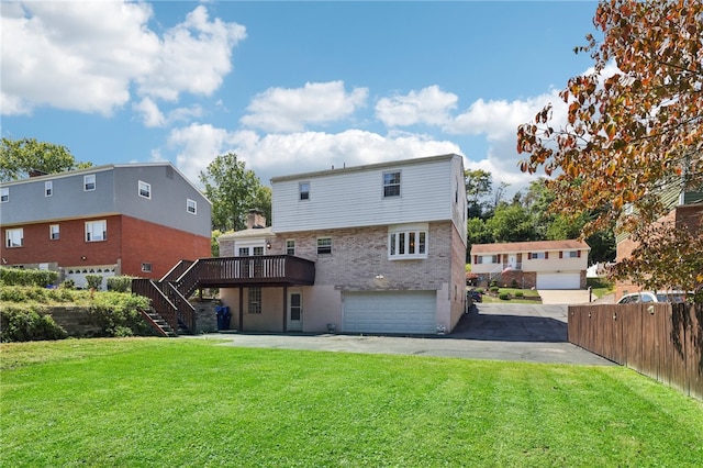 rear view of property featuring a wooden deck, a yard, and a garage