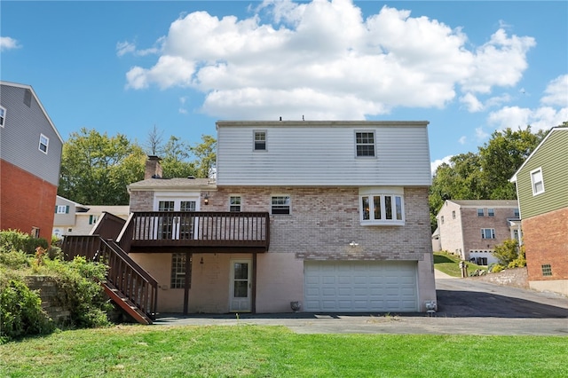 back of house with a yard, a garage, and a deck