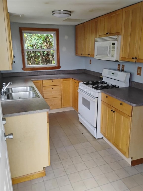 kitchen with white appliances, sink, and light tile patterned floors