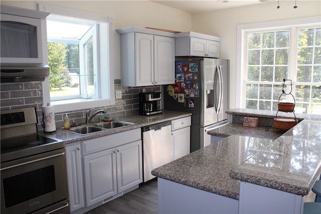 kitchen featuring a center island, tasteful backsplash, sink, white cabinets, and stainless steel appliances