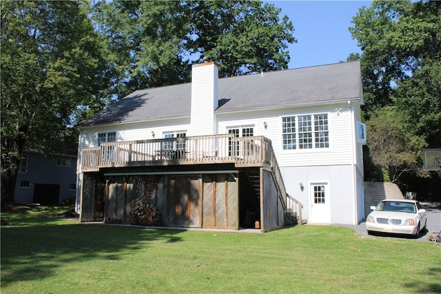 rear view of property featuring a lawn and a deck