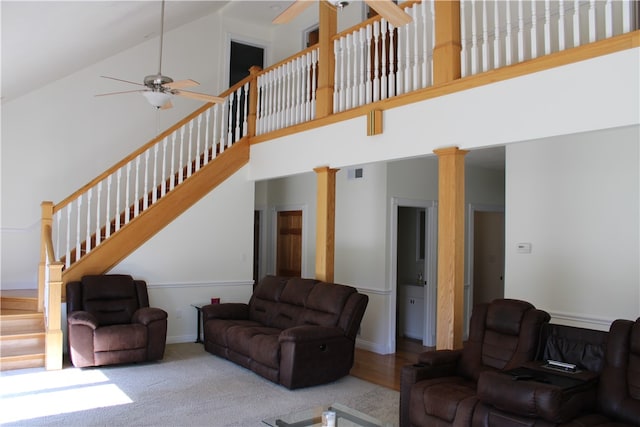 living room featuring ceiling fan, hardwood / wood-style floors, decorative columns, and high vaulted ceiling