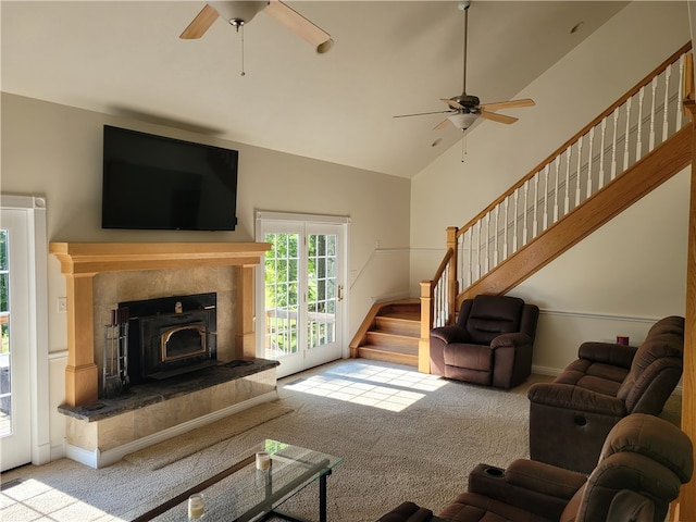 living room featuring ceiling fan, light carpet, and a tile fireplace