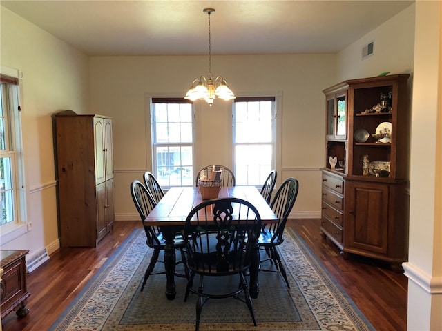 dining space featuring a chandelier and dark wood-type flooring