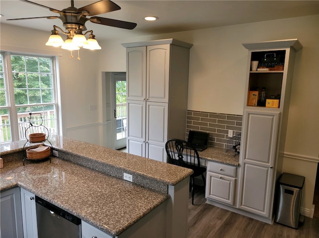 kitchen featuring light stone counters, dishwasher, dark hardwood / wood-style floors, decorative backsplash, and ceiling fan