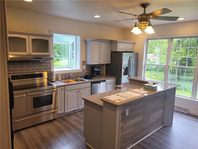 629 Euclid Ave, Grove City Boro, PA 16127 - kitchen featuring appliances with stainless steel finishes, decorative backsplash, a kitchen island, ceiling fan, and dark wood finished floors