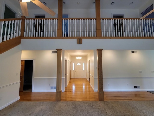 629 Euclid Ave, Grove City Boro, PA 16127 - unfurnished living room with carpet, ornate columns, baseboards, a chandelier, and wood finished floors
