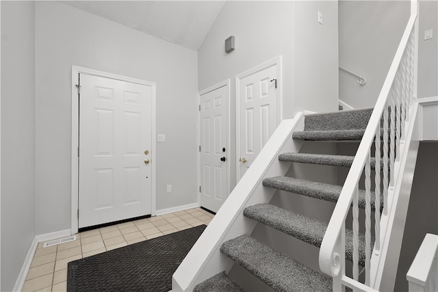 entrance foyer with vaulted ceiling and light tile patterned floors