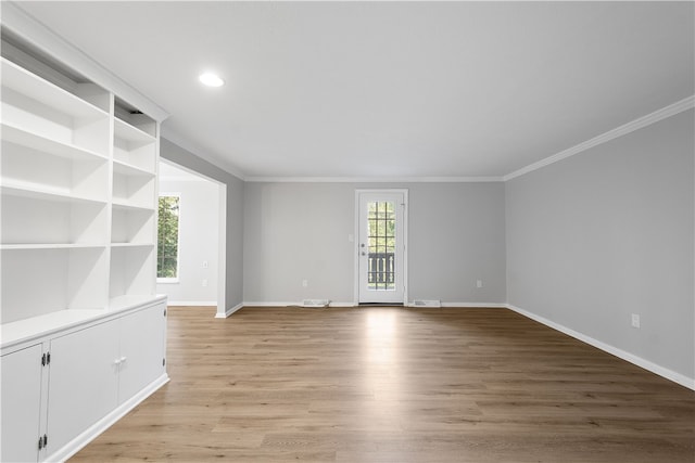 spare room featuring crown molding and light hardwood / wood-style floors