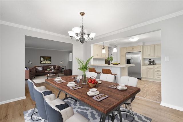 dining room featuring light wood-type flooring, ornamental molding, and an inviting chandelier