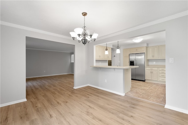 kitchen featuring hanging light fixtures, cream cabinets, stainless steel fridge with ice dispenser, and light hardwood / wood-style flooring