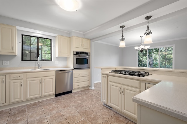 kitchen with appliances with stainless steel finishes, a chandelier, a wealth of natural light, and sink