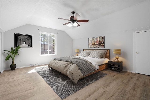 bedroom featuring ceiling fan, hardwood / wood-style flooring, and vaulted ceiling