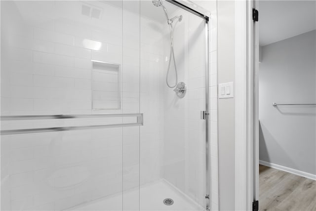 bathroom featuring hardwood / wood-style flooring and a shower with door