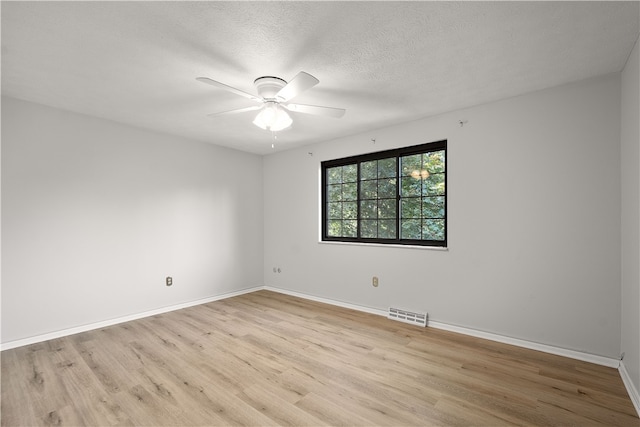 empty room featuring a textured ceiling, light hardwood / wood-style flooring, and ceiling fan