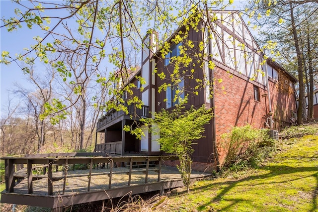 back of property featuring a deck and a lawn