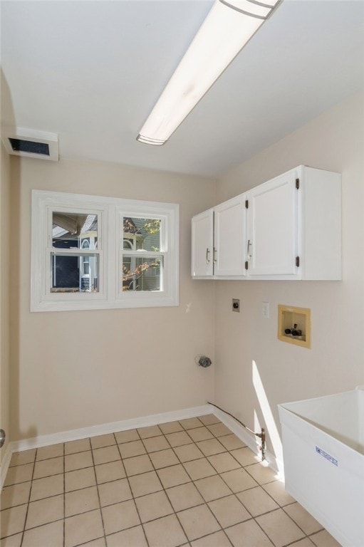 clothes washing area with washer hookup, light tile patterned flooring, cabinets, and hookup for an electric dryer