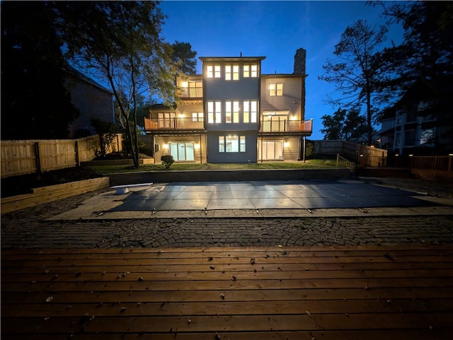 back house at twilight with a balcony