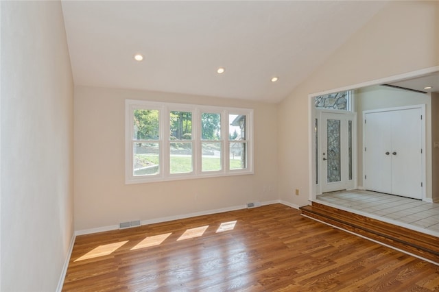 empty room featuring vaulted ceiling and light hardwood / wood-style floors