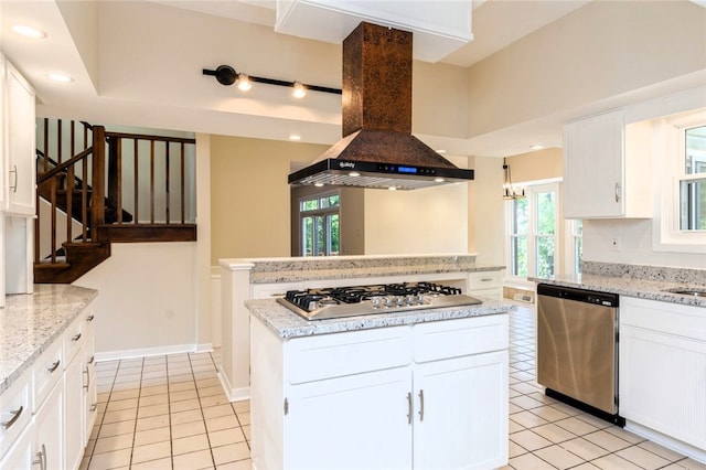 kitchen with exhaust hood, stainless steel appliances, white cabinets, and a healthy amount of sunlight