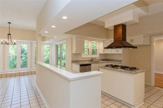 kitchen with a chandelier, stainless steel appliances, a center island, island exhaust hood, and white cabinets