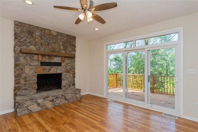 unfurnished living room with a fireplace, hardwood / wood-style flooring, a healthy amount of sunlight, and ceiling fan