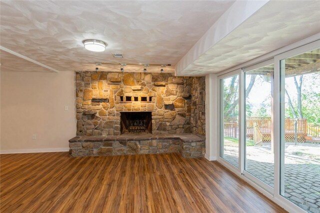 unfurnished living room featuring a textured ceiling, hardwood / wood-style floors, and a fireplace