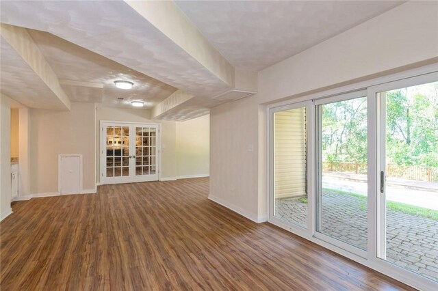 unfurnished living room featuring dark wood-type flooring and french doors