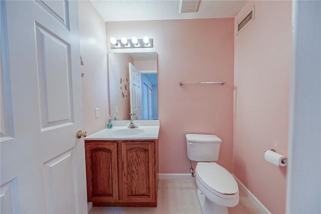 bathroom featuring vanity, toilet, and a textured ceiling