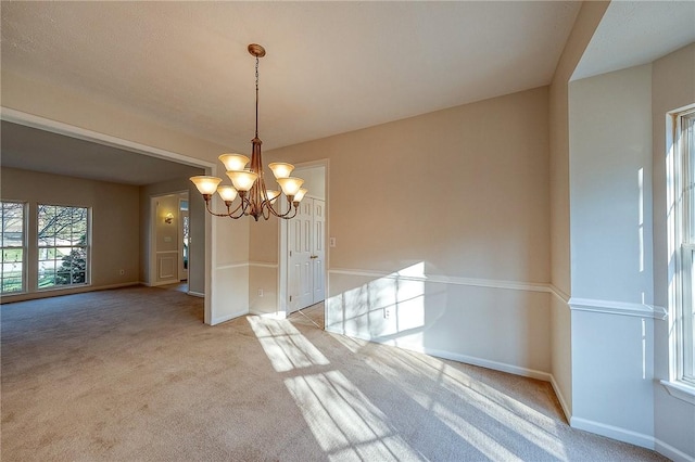 unfurnished dining area featuring light colored carpet and a notable chandelier