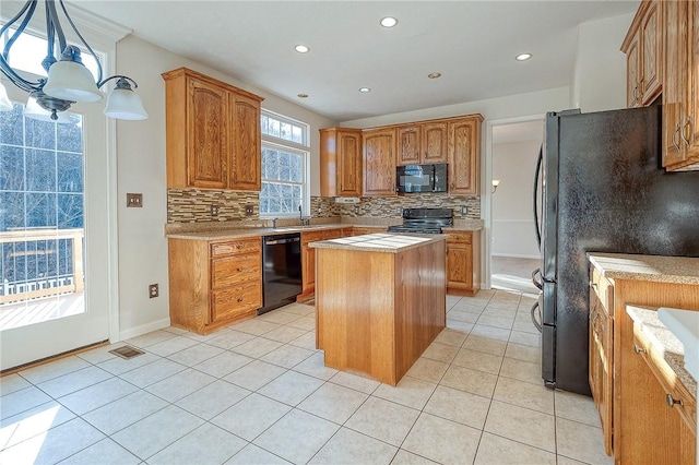 kitchen with a center island, sink, decorative light fixtures, light tile patterned flooring, and black appliances