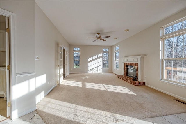 unfurnished living room featuring light colored carpet, a brick fireplace, and ceiling fan