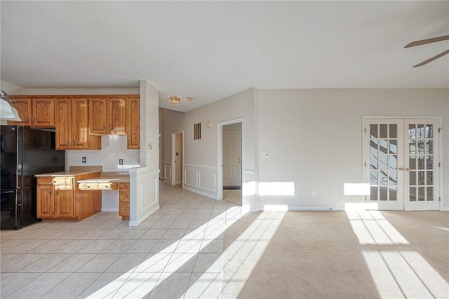 kitchen with ceiling fan, black fridge, light carpet, and french doors