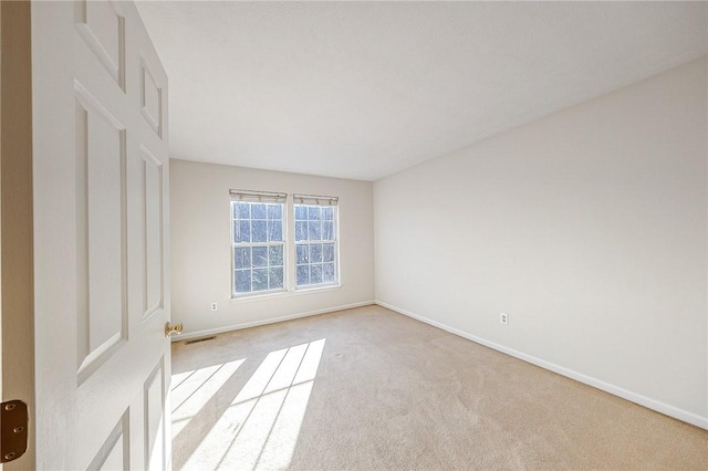 unfurnished room featuring light colored carpet