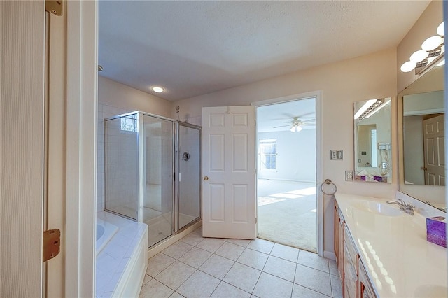 bathroom with plus walk in shower, tile patterned flooring, vanity, and a textured ceiling