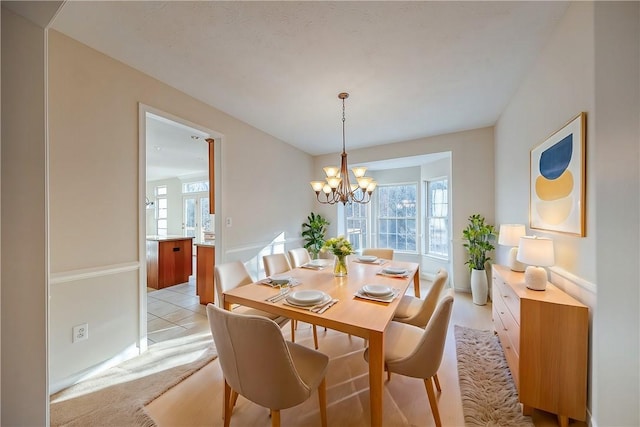 carpeted dining space featuring a chandelier