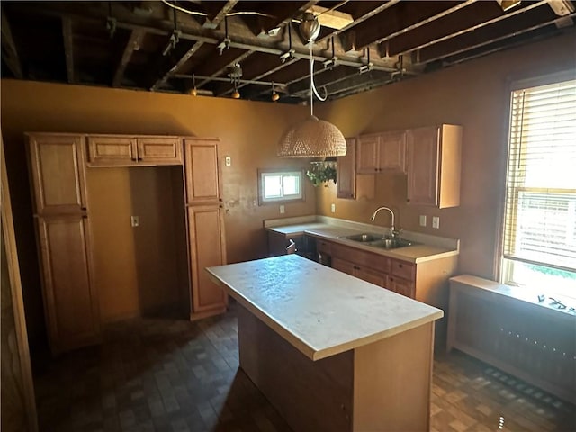 kitchen with dark wood-type flooring, a sink, a kitchen island, and light countertops
