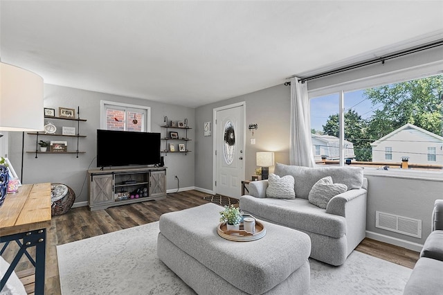 living room with a healthy amount of sunlight and dark hardwood / wood-style flooring