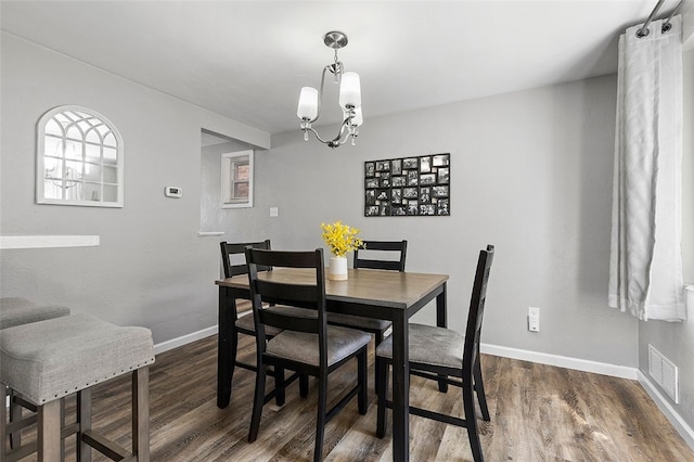 dining room with an inviting chandelier and dark hardwood / wood-style flooring