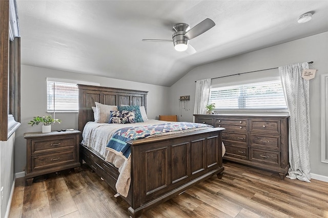 bedroom featuring lofted ceiling, multiple windows, ceiling fan, and dark hardwood / wood-style flooring