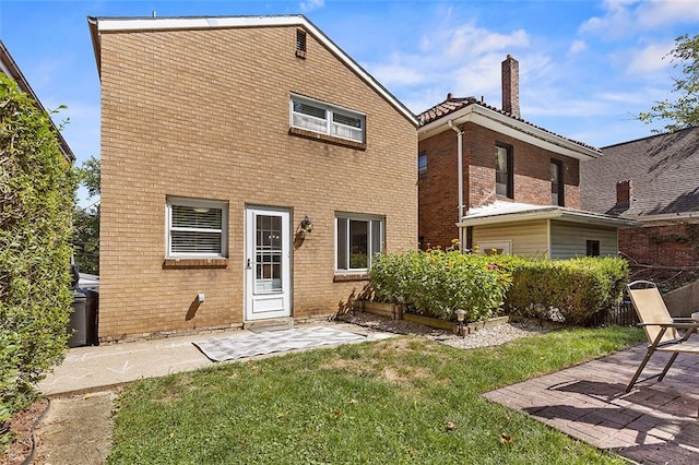 back of house with a lawn and a patio area